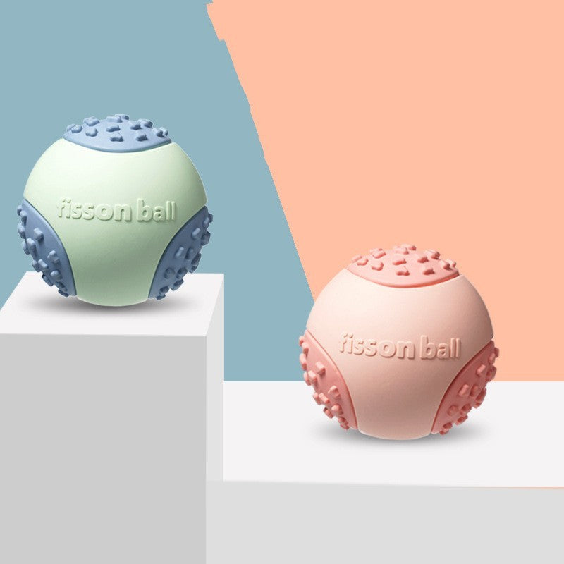 Two floating interactive rubber dog toy balls in green and pink colors, with a textured surface, displayed on a two-tone background.

