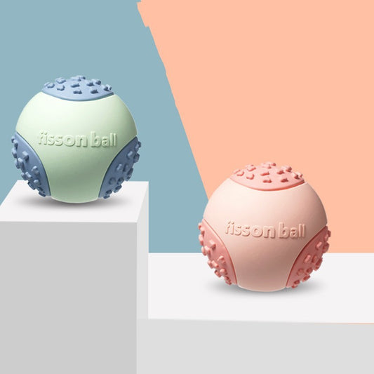 Two floating interactive rubber dog toy balls in green and pink colors, with a textured surface, displayed on a two-tone background.

